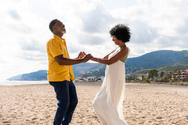 Beautiful mature black couple of lovers dating at the seaside - Married african middle-aged couple bonding and having fun outdoors, concepts about relationship, lifestyle and quality of life - DMDF11045