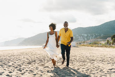 Beautiful mature black couple of lovers dating at the seaside - Married african middle-aged couple bonding and having fun outdoors, concepts about relationship, lifestyle and quality of life - DMDF11051