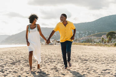 Beautiful mature black couple of lovers dating at the seaside - Married african middle-aged couple bonding and having fun outdoors, concepts about relationship, lifestyle and quality of life - DMDF11052