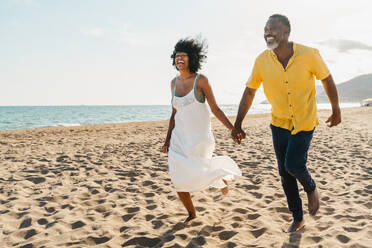 Beautiful mature black couple of lovers dating at the seaside - Married african middle-aged couple bonding and having fun outdoors, concepts about relationship, lifestyle and quality of life - DMDF11055