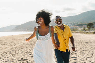 Beautiful mature black couple of lovers dating at the seaside - Married african middle-aged couple bonding and having fun outdoors, concepts about relationship, lifestyle and quality of life - DMDF11062