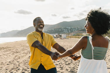 Beautiful mature black couple of lovers dating at the seaside - Married african middle-aged couple bonding and having fun outdoors, concepts about relationship, lifestyle and quality of life - DMDF11067