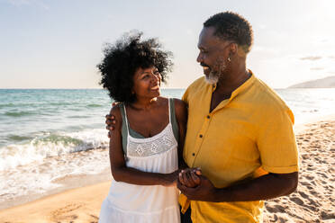 Beautiful mature black couple of lovers dating at the seaside - Married african middle-aged couple bonding and having fun outdoors, concepts about relationship, lifestyle and quality of life - DMDF11086