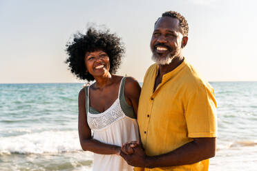 Beautiful mature black couple of lovers dating at the seaside - Married african middle-aged couple bonding and having fun outdoors, concepts about relationship, lifestyle and quality of life - DMDF11087