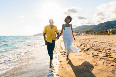 Beautiful mature black couple of lovers dating at the seaside - Married african middle-aged couple bonding and having fun outdoors, concepts about relationship, lifestyle and quality of life - DMDF11093