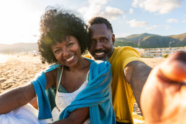 Beautiful mature black couple of lovers dating at the seaside - Married african middle-aged couple bonding and having fun outdoors, concepts about relationship, lifestyle and quality of life - DMDF11120