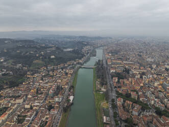 Aerial view of a residential district in Florence outskirts along the Arno river with mountains in background, Florence, Tuscany, Italy. - AAEF27577