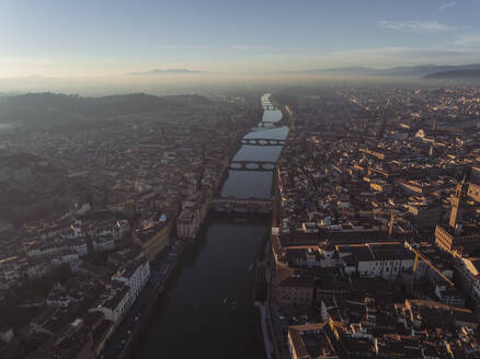 Aerial view of Ponte Vecchio crossing the Arno river in Florence downtown at sunset, Florence, Tuscany, Italy. - AAEF27582