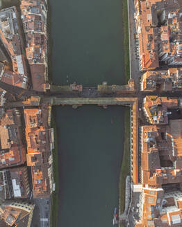 Aerial view of Ponte Vecchio crossing the Arno river in Florence downtown at sunset, Florence, Tuscany, Italy. - AAEF27588