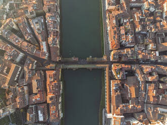 Aerial view of Ponte Vecchio crossing the Arno river in Florence downtown at sunset, Florence, Tuscany, Italy. - AAEF27589