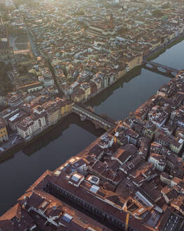 Aerial view of Ponte Vecchio crossing the Arno river in Florence downtown at sunset, Florence, Tuscany, Italy. - AAEF27611