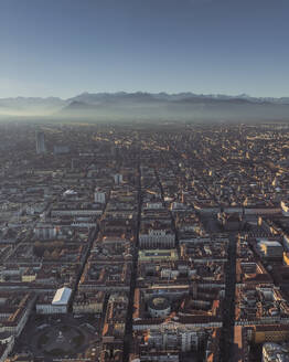 Aerial view of Turin downtown in evening haze at sunset with the Alps mountain range in background, Turin, Piedmont, Italy. - AAEF27639