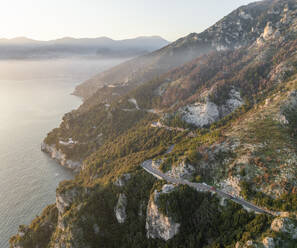 Aerial view of the scenic road along the Amalfi Coast facing the Mediterranean Sea at sunset, Amalfi, Salerno, Campania, Italy. - AAEF27669