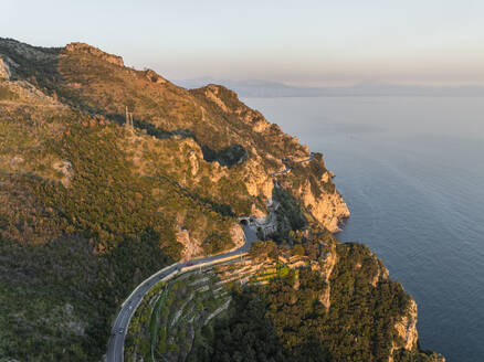 Aerial view of the scenic road along the Amalfi Coast facing the Mediterranean Sea at sunset, Amalfi, Salerno, Campania, Italy. - AAEF27670