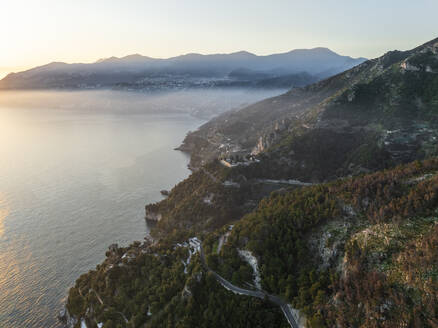 Aerial view of the scenic road along the Amalfi Coast facing the Mediterranean Sea at sunset, Amalfi, Salerno, Campania, Italy. - AAEF27673