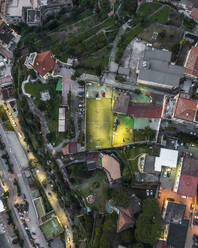 Aerial view of people playing football in a small field in Vietri sul Mare old town at sunset, a small town along the Amalfi Coast, Salerno, Campania, Italy. - AAEF27687