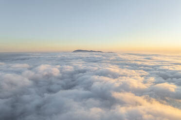 Aerial view of mountain range surrounded by low clouds at sunset as seen from the plane, Salerno, Campania, Italy. - AAEF27704