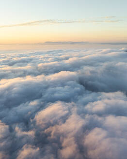 Aerial view of mountain range surrounded by low clouds at sunset and the Amalfi Coast in background as seen from the plane, Salerno, Campania, Italy. - AAEF27708