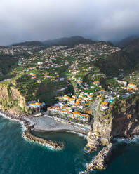 Aerial drone view of Ponta do Sol town during sunset, at the south coast of Madeira island, Portugal. - AAEF27720