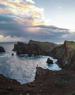 Aerial drone view a person standing at Ponta do Castelo during sunrise, Eastern Peninsula of Madeira island, Portugal. - AAEF27725