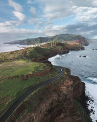 Aerial drone view a car driving along the cliffs during sunrise, Eastern Peninsula, Madeira island, Portugal. - AAEF27728