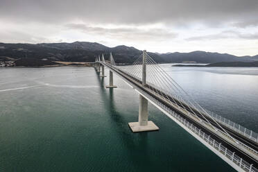 Aerial view of Peljeski Most bridge over clear blue waters, Croatia. - AAEF27882