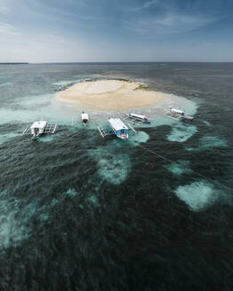 Luftaufnahme einer Drohne von Longtail-Touristenbooten, die an der nackten Insel Siargao, Surigao del Norte, Philippinen, angedockt sind. - AAEF27995