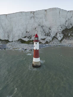 Aerial drone view of the Seven Sisters Cliffs National Park with lighthouse during sunset in the Eastbourne, England, United Kingdom. - AAEF28001