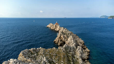 Drohnenansicht der einsamen Felseninsel mit Leuchtturm in Dubrovnik, Kroatien. - AAEF28058