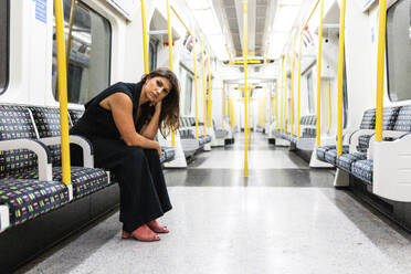 Thoughtful young woman sitting in subway train - WPEF08582