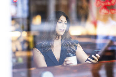 Young woman using smart phone in cafe - WPEF08607