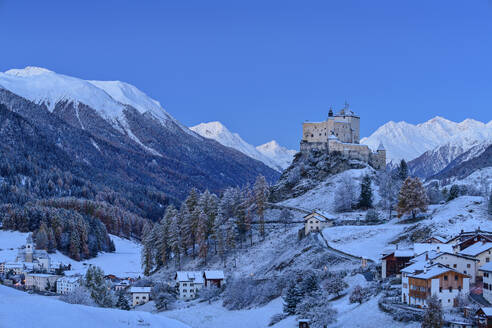 Schloss Tarasp in der Nähe von Häusern und schneebedeckten Sesvenna Alpen, Tarasp, Unterengadin, Engadin, Graubünden, Schweiz - ANSF00789