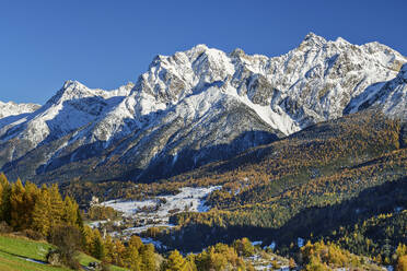 Snowcapped mountains with green trees on sunny day, Ardez, Lower Engadine, Engadine, Grisons, Switzerland - ANSF00801