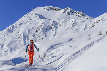 Ältere Frau beim Skitourengehen am Junsjoch mit Rucksack, Pluderling, Tuxer Alpen, Tirol, Österreich - ANSF00846
