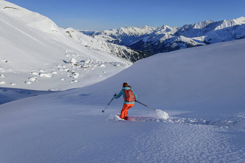 Frau beim Skifahren auf dem Junsjoch mit den Zillertaler Alpen im Hintergrund, Tuxer Alpen, Tirol, Österreich - ANSF00851