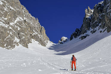 Mature woman back country skiing on Gruensteinscharte at Grunstein, Mieming Range, Tyrol, Austria - ANSF00858