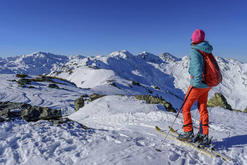 Ältere Frau mit Rucksack beim Skifahren auf dem schneebedeckten Kastenwendenkopf, Kitzbüheler Alpen, Tirol, Österreich - ANSF00863