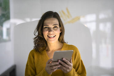 Lächelnde kreative Geschäftsfrau mit Tablet-PC im Büro - KNSF10160