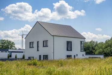 Modernes Einfamilienhaus unter wolkenverhangenem Himmel in Bayern, Deutschland - MAMF02958