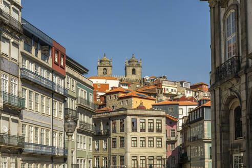 Portugal, Northern Portugal, Porto, Apartment buildings with twin bell towers looming in background - JMF00652