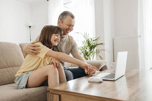 Happy father and daughter watching movie and having fun at home - ELMF00117