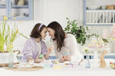 Mutter und Tochter feiern Ostern zu Hause von Angesicht zu Angesicht - ONAF00736