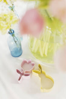 Colorful cookie cutters and flowers on table - ONAF00742