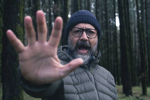 Wütender Mann zeigt Stopp-Geste im Wald - SIPF02899