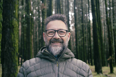Bearded man wearing eyeglasses in forest - SIPF02902