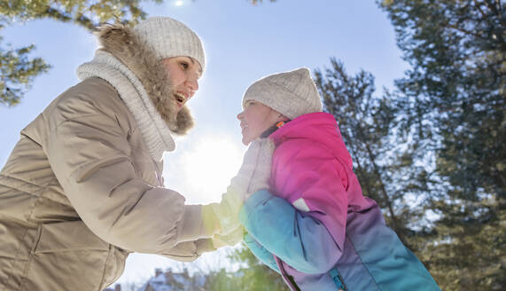 Cheerful mother and daughter playing in winter forest - MBLF00305