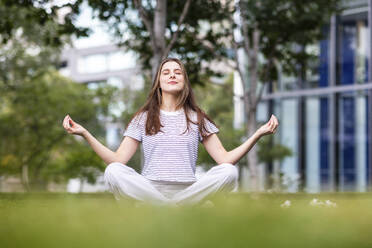 Young woman meditating in park - WPEF08666