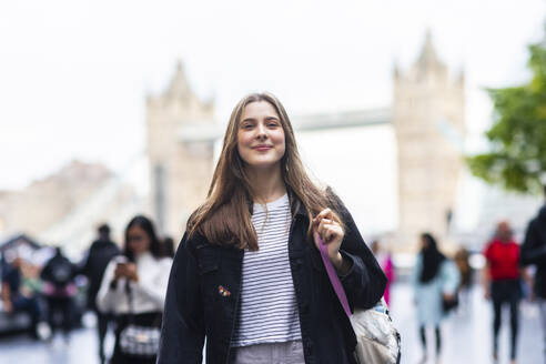 Lächelnde junge Frau vor der Tower Bridge in London City, England, UK - WPEF08670