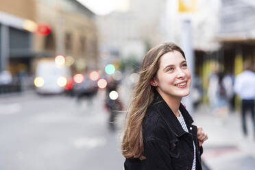 Happy beautiful woman with long hair on street - WPEF08675