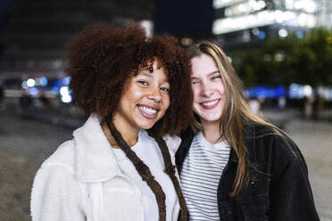 Lächelnde junge Freunde in der Stadt bei Nacht - WPEF08701